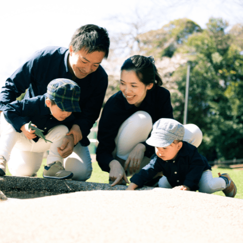 外でしゃがんでいる4人家族