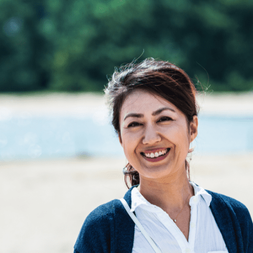 屋外でほほ笑む60代の女性